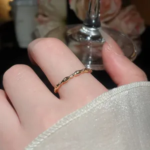 Primo piano di un anello minimalista ondulato placcato oro 18k con zirconi