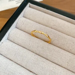 Primo piano di un anello ondulato placcato oro 18 carati con pietre di zirconia cubica