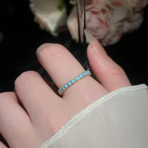 Primo piano di un delicato anello placcato oro con pietre turchesi in stile vintage.