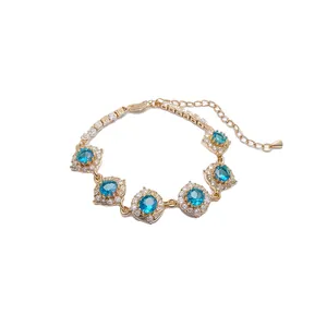 Elegante bracciale placcato oro 18 carati con scintillanti fiori in zirconia blu.