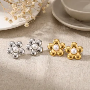 Vue détaillée de boucles d'oreilles fleur en acier doré 18K et argent avec perles