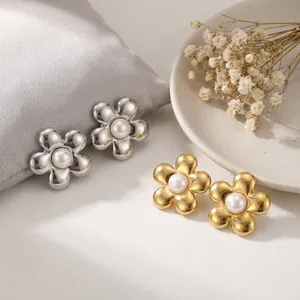 Vue détaillée de boucles d'oreilles fleurs dorées et argentées avec perle centrale