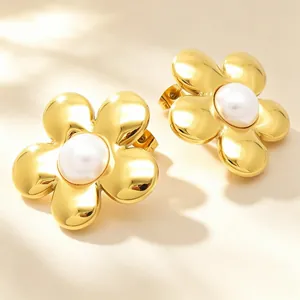 Gros plan sur des boucles d'oreilles fleur en or 18 carats avec perle blanche centrale