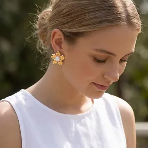 Vue rapprochée d'élégantes boucles d'oreilles fleurs en or 18 carats ornées d'une perle.