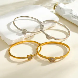 Close-up of four rhinestone inlaid stainless steel bangles in gold and silver finish