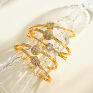 Detail view of gold-plated stainless steel bangles with sparkling zircon leaf designs