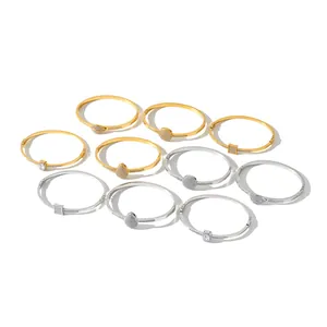 Variety of stainless steel bangles with geometric rhinestone charms in gold and silver.
