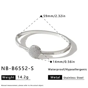 Detailed view of silver stainless steel bangle featuring a pavé-set round zircon charm