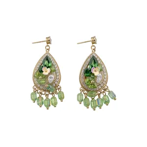 Bohemian teardrop earrings with green crystals and floral details in gold finish