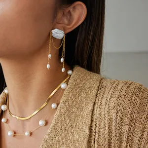 Elegante primo piano di orecchini con nappe di perle e set di collana a strati d'oro