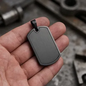 Detailed close-up of a masculine matte black stainless steel dog tag pendant with a brushed finish.