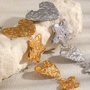 Gros plan d'un collier en acier inoxydable doré 18K avec breloques cœur et étoile martelées.