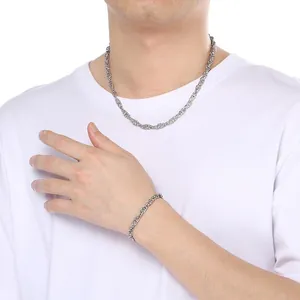 Model wearing a unisex silver twisted stainless steel braided necklace and bracelet set