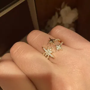 Primo piano di un anello aperto placcato oro 18k con stelle di zircone scintillanti