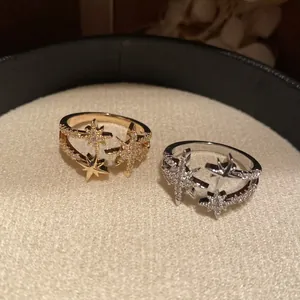 Primo piano di due anelli a stella placcati in oro 18 carati con zirconi in oro e argento.