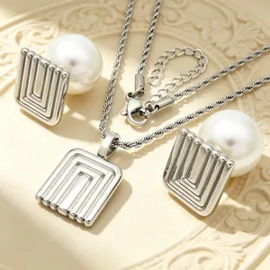 Macro detail of French retro pearl jewelry set with geometric square metal texture.