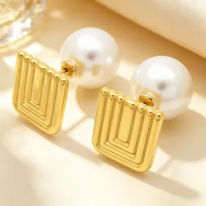 Close-up of French vintage gold geometric square earrings with large white pearls