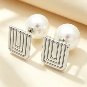 Close-up of retro square geometric stainless steel earrings with large white pearls
