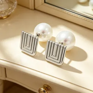 Detailed macro shot of vintage silver geometric square earrings with large white pearls