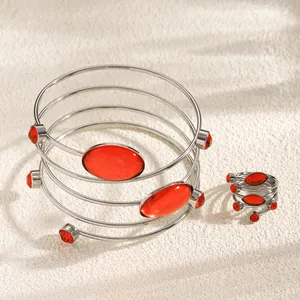 Close-up of French style spiral silver-tone bracelet and ring set with red gems