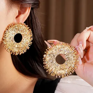 Orecchini a raggiera in oro con strass e design traforato per uno stile audace e unico
