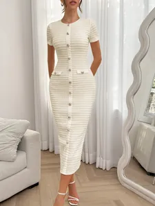 Detailansicht eines eleganten weißen Strickkleids mit goldfarbenen Knöpfen