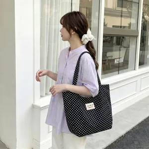 Large capacity black and white polka dot canvas tote bag for women shown on model