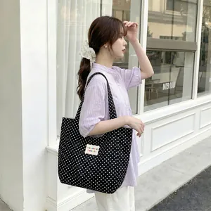 Stylish large capacity polka dot canvas tote bag carried by a model outdoors