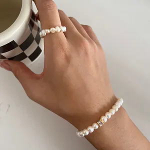 Close-up detail of baroque natural freshwater pearl bracelet and matching ring worn on hand