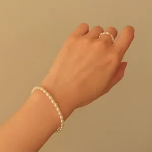 Detailed view of baroque freshwater pearl bracelet and matching ring on model's hand