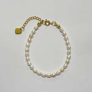 Exquisite detail of baroque freshwater pearl bracelet featuring a gold heart charm