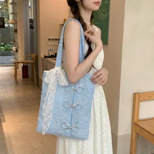 Side view of a blue sequined canvas tote bag with bow details worn by a model