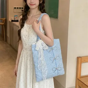 Lifestyle detail showing a blue sequin canvas tote bag with lace bow and silver ribbon