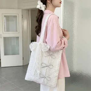 White sequin canvas tote bag with lace bow decoration shown on a model's shoulder