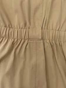 Detailed macro shot of khaki shirt dress featuring elastic waistband and fine stitching