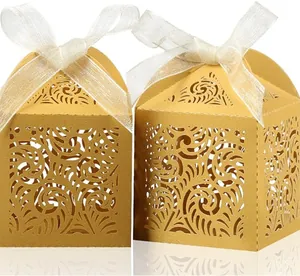 Detailed view of elegant gold laser-cut hollow wedding favor boxes with white ribbon bows