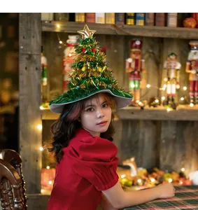 Detail view of a green tinsel Christmas tree hat worn by a model in a cozy setting