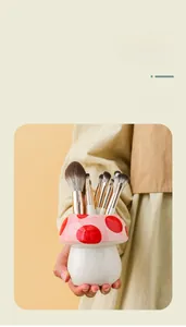 Gros plan d'un pot à crayons en céramique en forme de champignon pour pinceaux