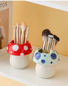 Close-up of cute mushroom-shaped ceramic holders storing makeup brushes in red and blue