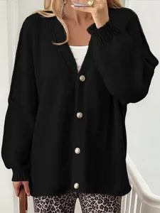 Close-up detail of a women's black knitted cardigan featuring elegant gold buttons