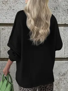 Back view of a cozy oversized black knitted sweater with a textured finish.