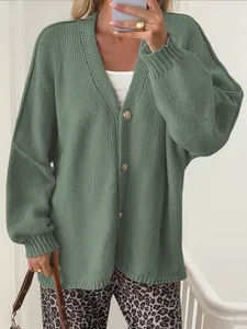 Detailed macro view of a sage green knitted cardigan featuring ornate gold buttons.