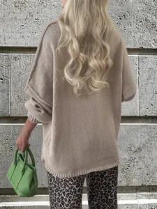 Detailed back view of an oversized beige knitted sweater showing soft textured fabric.