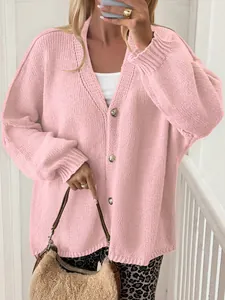 Detail view of stylish pink knit cardigan with gold buttons and oversized fit design