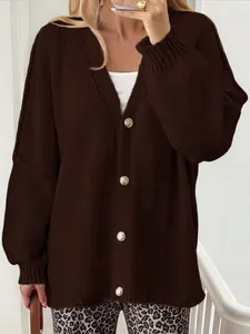 Close-up detail of a dark brown knit cardigan featuring elegant gold button accents.