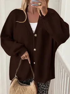 Close-up detail of a women's brown knitted cardigan with elegant gold buttons
