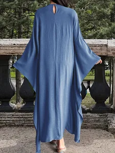 Vue arrière d'une élégante robe longue bleu uni avec manches chauve-souris et dos nu
