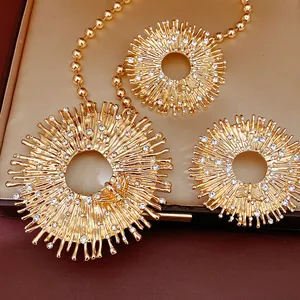Dettaglio ravvicinato di set collana sole dorato con strass e motivo abe decorativo