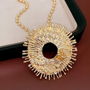 Primo piano di un'elegante collana con ciondolo a sole dorato con strass e motivo ad ape