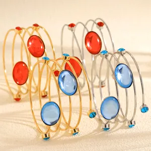Detailed view of spiral geometric bracelets with blue and red gemstones
